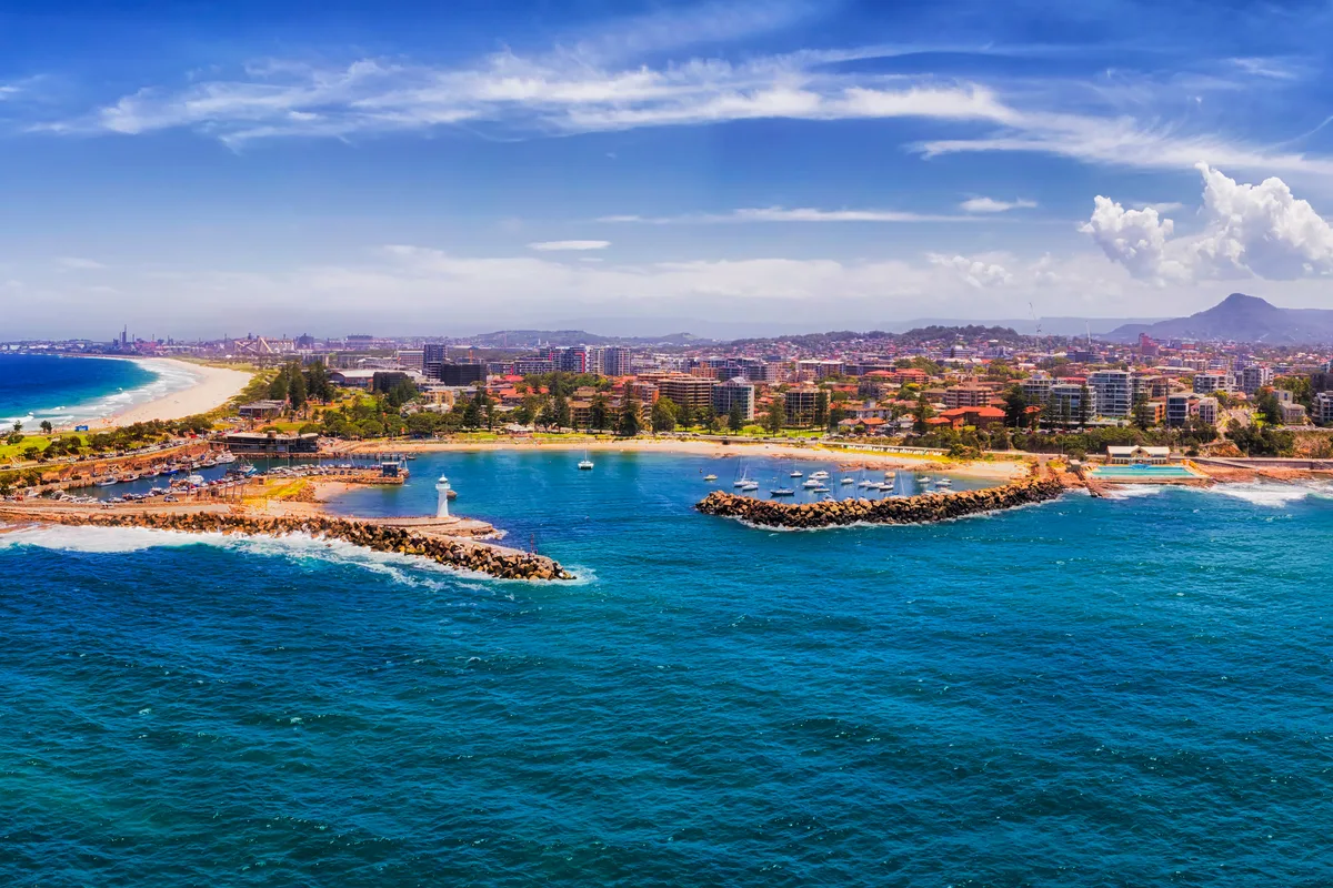 Panoramic aerial of the Wollongong coastline, harbour and city with the Illawarra escarpment behind